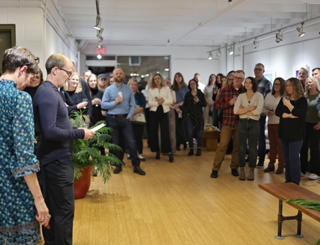 Dave Carpenter presenting to a crowd of people in the gallery.